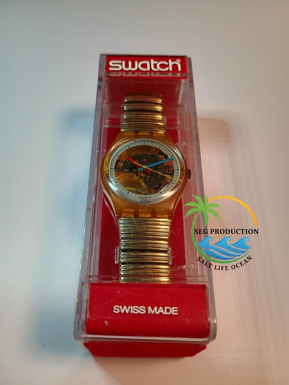 Swatch Gold Transparent Dial Watch with Blue and Red Hands